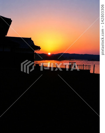 The water's surface is dyed crimson, and the shadows of Japan fade into the twilight. The water's surface is dyed crimson, and the shadows of Japan fade into the twilight. 142803306