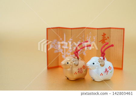 New Year's greeting card material for the Year of the Sheep: Cute gold and silver sheep and a gold folding screen, gold background. New Year's greeting card material for the Year of the Sheep: Cute gold and silver sheep and a gold folding screen, gold background. 142803461