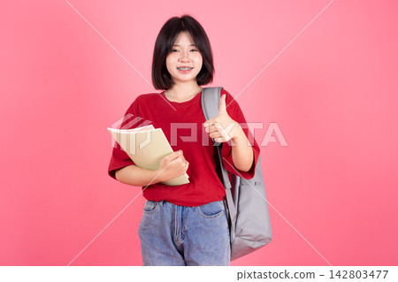 Asian Female Student Backpack Hand Thumbs up on Pink Studio Background for Good Education Asian Female Student Backpack Hand Thumbs up on Pink Studio Background for Good Education 142803477