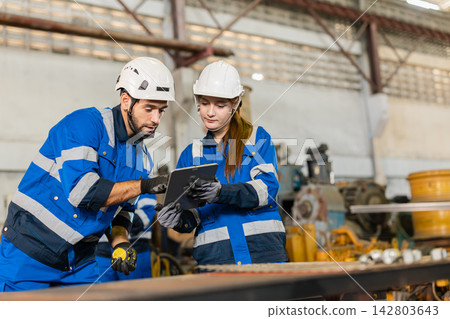 Factory Latino Technician Working together team with Black Worker Friend In Old Heavy Machinery Spare Parts Warehouse. 142803643