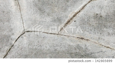 Distressed Grey Concrete Surface with Intersecting Cracks Distressed Grey Concrete Surface with Intersecting Cracks 142803899