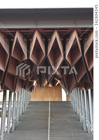 A modern staircase with an impressive geometric wooden structure. A modern staircase with an impressive geometric wooden structure. 142804345