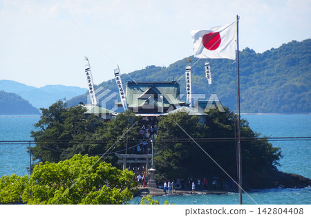 香川縣三豐市對馬神社夏季祭典：位於海邊的主神社，國旗和旗幟在風中飄揚。 142804408