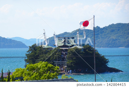 香川縣三豐市對馬神社夏季祭典:位於海邊的主神社,國旗和旗幟在風中飄揚。 香川縣三豐市對馬神社夏季祭典:位於海邊的主神社,國旗和旗幟在風中飄揚。 142804415