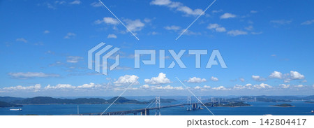 The Seto Ohashi Bridge (a bridge connecting Okayama and Kagawa prefectures) spans the Seto Inland Sea against a backdrop of blue sky. The Seto Ohashi Bridge (a bridge connecting Okayama and Kagawa prefectures) spans the Seto Inland Sea against a backdrop of blue sky. 142804417