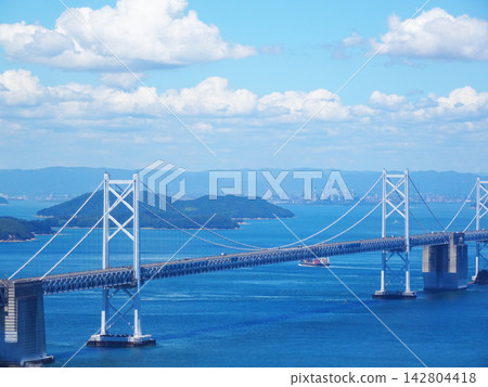 The Seto Ohashi Bridge (a bridge connecting Okayama and Kagawa prefectures) spans the Seto Inland Sea against a backdrop of blue sky. The Seto Ohashi Bridge (a bridge connecting Okayama and Kagawa prefectures) spans the Seto Inland Sea against a backdrop of blue sky. 142804418
