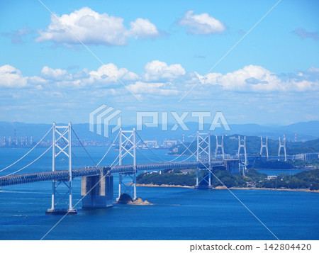 The Seto Ohashi Bridge (a bridge connecting Okayama and Kagawa prefectures) spans the Seto Inland Sea against a backdrop of blue sky. The Seto Ohashi Bridge (a bridge connecting Okayama and Kagawa prefectures) spans the Seto Inland Sea against a backdrop of blue sky. 142804420