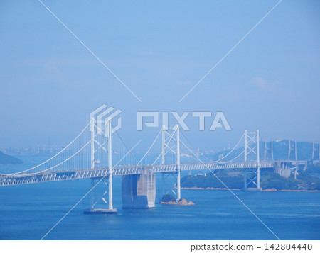 The Seto Ohashi Bridge (a bridge connecting Okayama and Kagawa prefectures) spans the Seto Inland Sea against a backdrop of blue sky. The Seto Ohashi Bridge (a bridge connecting Okayama and Kagawa prefectures) spans the Seto Inland Sea against a backdrop of blue sky. 142804440