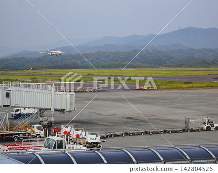 An ANA passenger aircraft landing on the runway at Takamatsu Airport, along with ground handling facilities (Kagawa Prefecture). An ANA passenger aircraft landing on the runway at Takamatsu Airport, along with ground handling facilities (Kagawa Prefecture). 142804526