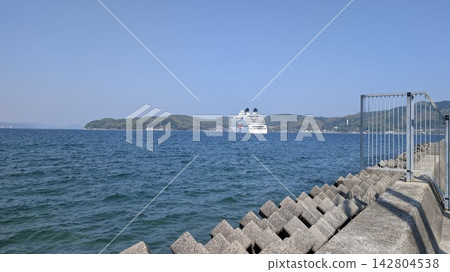 一艘客輪在湛藍的天空和大海上航行,構成了一幅寧靜祥和的畫面。 一艘客輪在湛藍的天空和大海上航行,構成了一幅寧靜祥和的畫面。 142804538