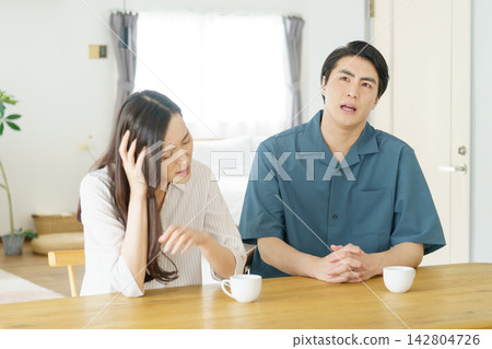 一對年輕的日本夫婦在客廳爭吵 一對年輕的日本夫婦在客廳爭吵 142804726