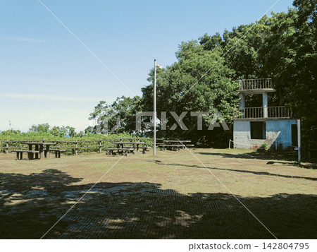 The plaza and observation deck at the Sarushima Fortress ruins, surrounded by blue skies and lush green trees. The plaza and observation deck at the Sarushima Fortress ruins, surrounded by blue skies and lush green trees. 142804795