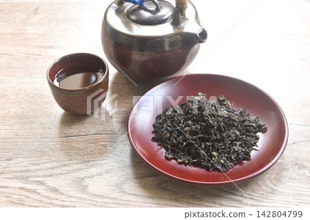 dry Chinese tea leaves with pottery pot and glass on table dry Chinese tea leaves with pottery pot and glass on table 142804799