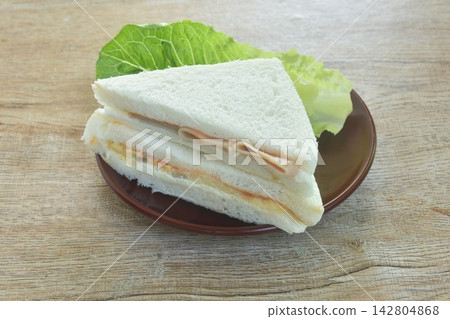 bologna and egg cheese sandwich with fresh cos lettuce on plate bologna and egg cheese sandwich with fresh cos lettuce on plate 142804868