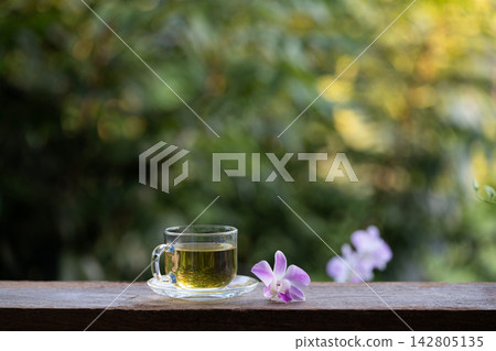 Tea in a glass cup and purple orchid 142805135