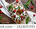 Glazed Bundt Cake with Fresh Fruits and White Icing 142805393