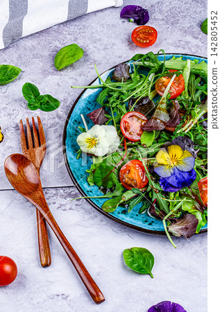 Arugula and Tomato Salad with Edible Flowers on Gray Background Arugula and Tomato Salad with Edible Flowers on Gray Background 142805452