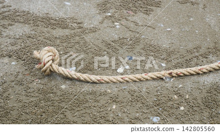 Close-Up of Knotted Rope End on Sandy Beach Close-Up of Knotted Rope End on Sandy Beach 142805560