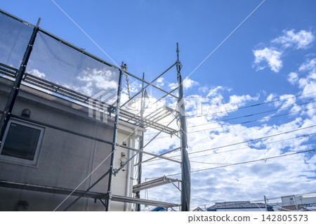 Temporary scaffolding for exterior wall and roof renovations and open sky Temporary scaffolding for exterior wall and roof renovations and open sky 142805573