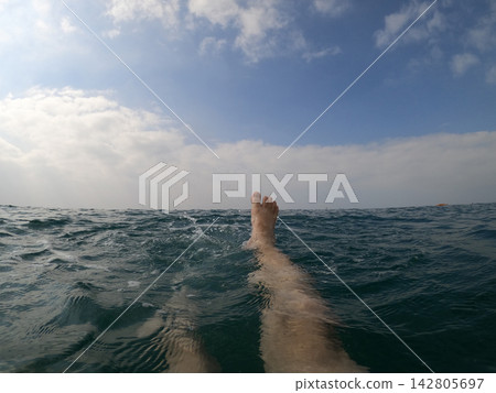 feet of a man swimming in the sea feet of a man swimming in the sea 142805697