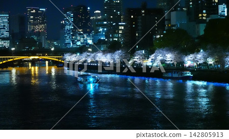 夜晚,河岸上櫻花盛開,燈光璀璨。 夜晚,河岸上櫻花盛開,燈光璀璨。 142805913