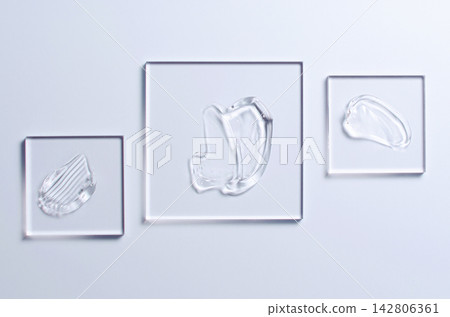 A sample of a transparent cosmetic skin care product on glass. Blue background A sample of a transparent cosmetic skin care product on glass. Blue background 142806361