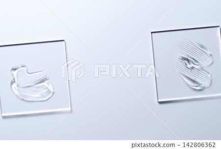 A sample of a transparent cosmetic skin care product on glass. Blue background A sample of a transparent cosmetic skin care product on glass. Blue background 142806362