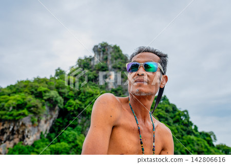 Asian man wearing sunglasses on vacation in thailand Asian man wearing sunglasses on vacation in thailand 142806616