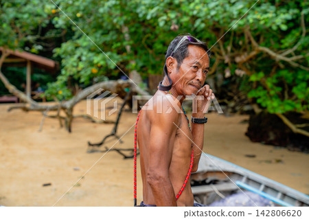 Moken man on sandy beach looking away Moken man on sandy beach looking away 142806620