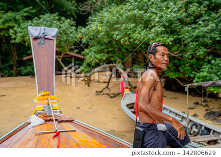Local thai man standing by longtail boat Local thai man standing by longtail boat 142806629