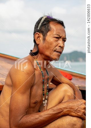 Moken man wearing traditional necklace on boat Moken man wearing traditional necklace on boat 142806633