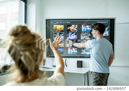 Teen boy presenting school project in front of classroom. 142806937