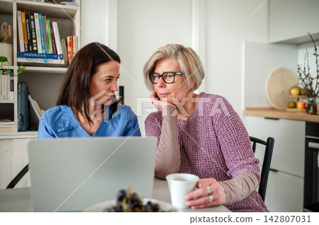 Elderly woman learning how to work with laptop, social worker helping her. Elderly woman learning how to work with laptop, social worker helping her. 142807031
