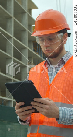 Vertical video. Architect analyzing project plan on construction site with touchpad. Vertical video. Architect analyzing project plan on construction site with touchpad. 142807032