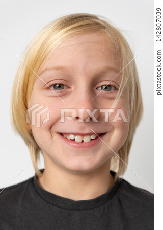 Young blond boy smiling brightly, expressing authentic happiness and innocence, a missing front tooth highlighting his age and the natural process of growing up Young blond boy smiling brightly, expressing authentic happiness and innocence, a missing front tooth highlighting his age and the natural process of growing up 142807039