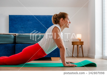 Woman practicing yoga in bedroom at home. Woman practicing yoga in bedroom at home. 142807098