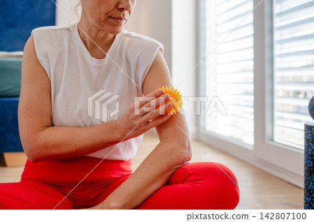Top view of middle aged woman exercising, massaging herself. Top view of middle aged woman exercising, massaging herself. 142807100