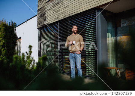 Relaxed man drinking coffee on terrace at home on sunny day. Relaxed man drinking coffee on terrace at home on sunny day. 142807129