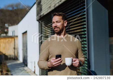 Relaxed man drinking coffee on terrace at home on sunny day. Relaxed man drinking coffee on terrace at home on sunny day. 142807130