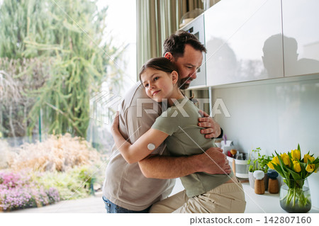 Dad hugging with daughter with diabetes in kitchen at home. Dad hugging with daughter with diabetes in kitchen at home. 142807160