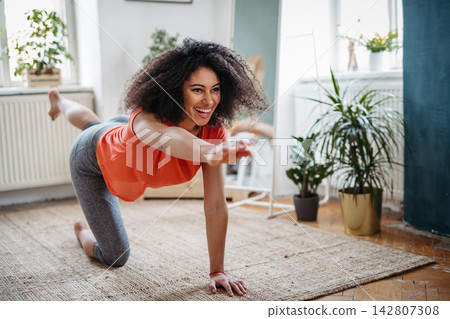 Young woman during home workout. Young woman during home workout. 142807308