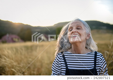 Senior woman enjoying gentle outdoor activity and connection with nature. Senior woman enjoying gentle outdoor activity and connection with nature. 142807321