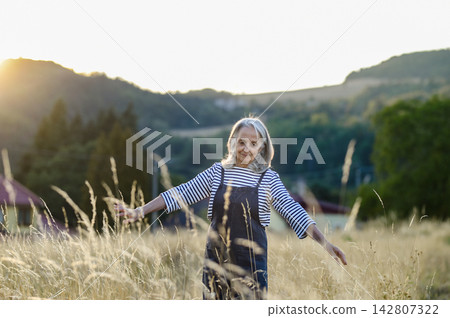 Senior woman enjoying gentle outdoor activity and connection with nature. Senior woman enjoying gentle outdoor activity and connection with nature. 142807322