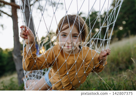 Young girl relaxing in hammock during family camping trip. Young girl relaxing in hammock during family camping trip. 142807375
