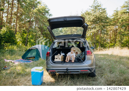 Family getting camping equipment from car after arriving in nature. 142807429