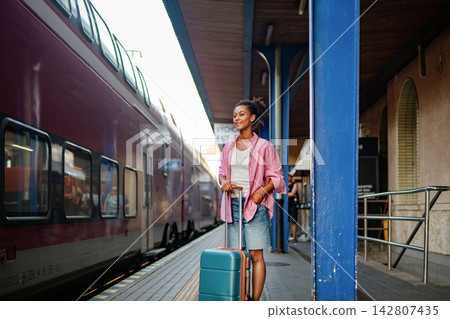 Female college student traveling back to campus for new academic year. Female college student traveling back to campus for new academic year. 142807435