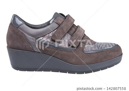 Grey brown suede women wedge shoes with hook and loop straps isolated on white background Grey brown suede women wedge shoes with hook and loop straps isolated on white background 142807558