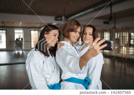 Three karate athletes taking selfie after training. 142807560