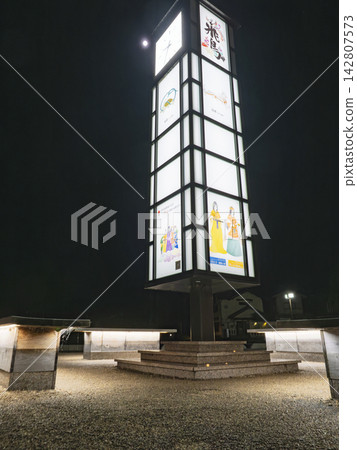 A lantern-style clock tower monument stands out in front of Asuka Station at night. A lantern-style clock tower monument stands out in front of Asuka Station at night. 142807573
