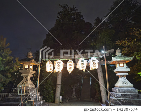 夜晚,奇幻的節日燈籠和石燈籠照亮了神社。 夜晚,奇幻的節日燈籠和石燈籠照亮了神社。 142807574